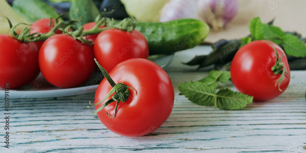 Tomatoes, cucumbers and mint leaves on a wooden table, organic natural vegetables Tomatoes, cucumbers and mint leaves on a wooden table, organic natural vegetables