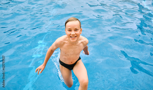Child jump, swim in the pool, sunbathes, swimming in hot summer day. Relax, Travel, Holidays, Freedom concept. © Andrii IURLOV