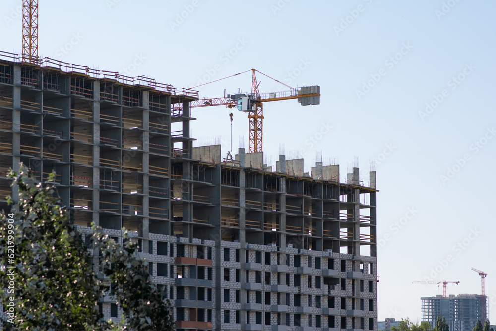 Construction of a new multi-storey building on the site of a residential complex. Lifting crane at work