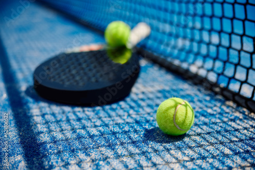 Paddle tennis equipment on ground at outdoor court.