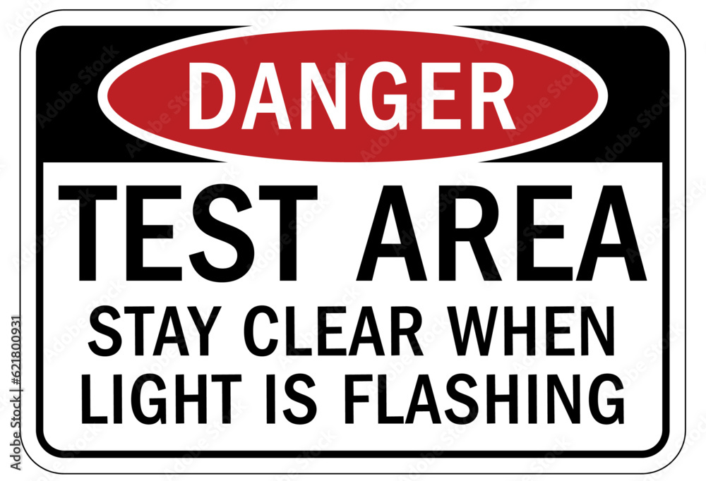 Testing in progress warning sign and labels test area. Stay clear when light is flashing Testing in progress warning sign and labels test area. Stay clear when light is flashing