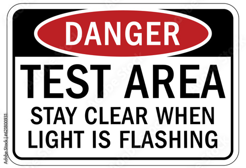 Testing in progress warning sign and labels test area. Stay clear when light is flashing