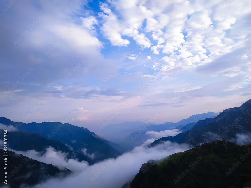Mountain landscape with clouds and blue sky at sunrise, India.