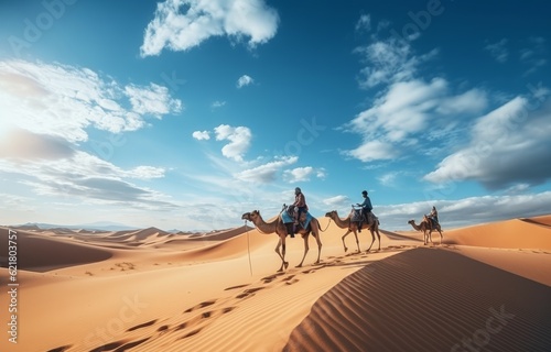People riding camels on a sand dune in the desert