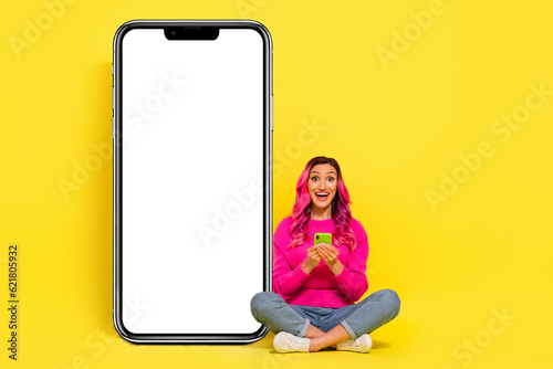 Full length photo of impressed girl dressed pullover reading modern gadget empty space isolated yellow color background