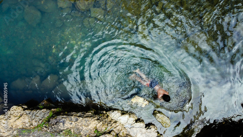 Top view of little boy swimming in river