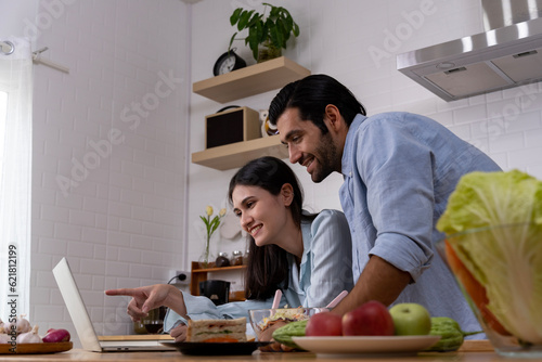 Young couple enjoy while cooking meal in kitchen at home