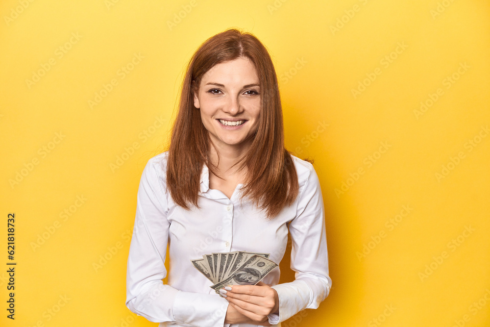 Redhead with dollar bills, cash in hand laughing and having fun. Redhead with dollar bills, cash in hand laughing and having fun.