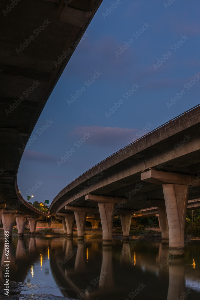 Underside of an elevated road across river at dusk Underside of an elevated road across river at dusk