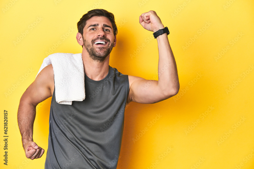 Sporty Caucasian man with towel, studio shot on yellow Sporty Caucasian man with towel, studio shot on yellowraising fist after a victory, winner concept. Sporty Caucasian man with towel, studio shot on yellow Sporty Caucasian man with towel, studio shot on yellowraising fist after a victory, winner concept.