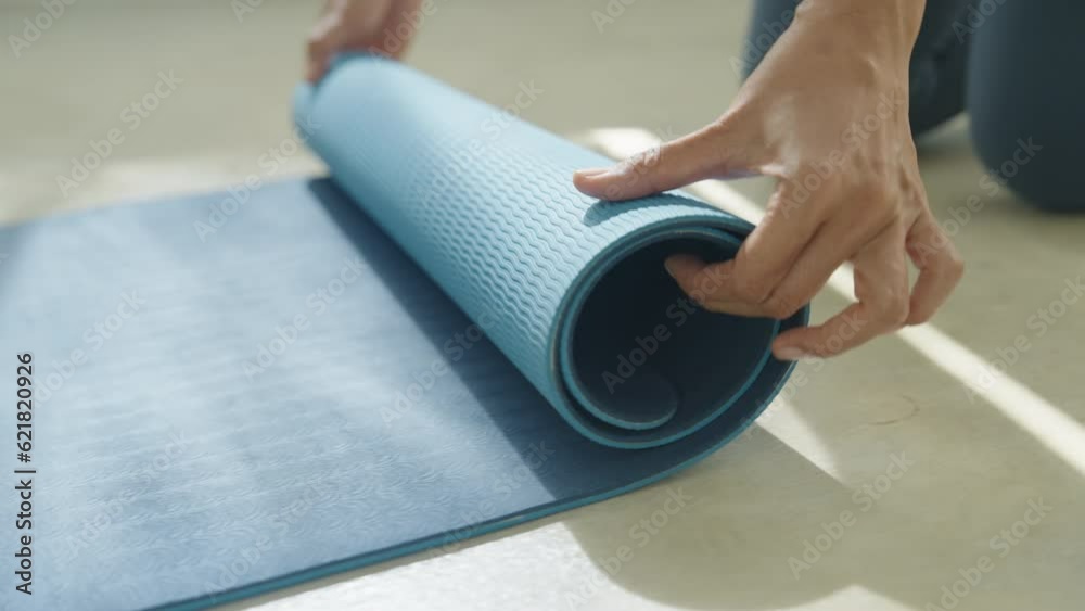 Hand of asian woman mat yoga apart rolling up and preparing to doing yoga class 