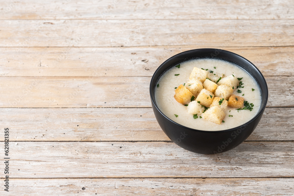 Cauliflower soup in a bowl on wooden table. Copy space Cauliflower soup in a bowl on wooden table. Copy space
