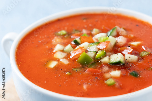Traditional Spanish gazpacho soup in bowl on blue background. Close up