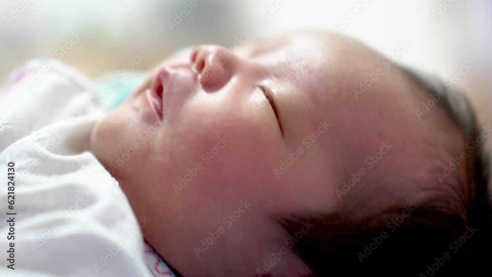 Asian infant baby boy newborn move his hands while asleep try to open his eyes and look around Asian infant baby boy newborn move his hands while asleep try to open his eyes and look around