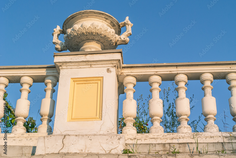 Fototapeta premium A vase made of stucco on an old building of the 19th century. A flowerpot on the facade of a mansion built in the 19th century. Ancient architecture with stucco on the facade.