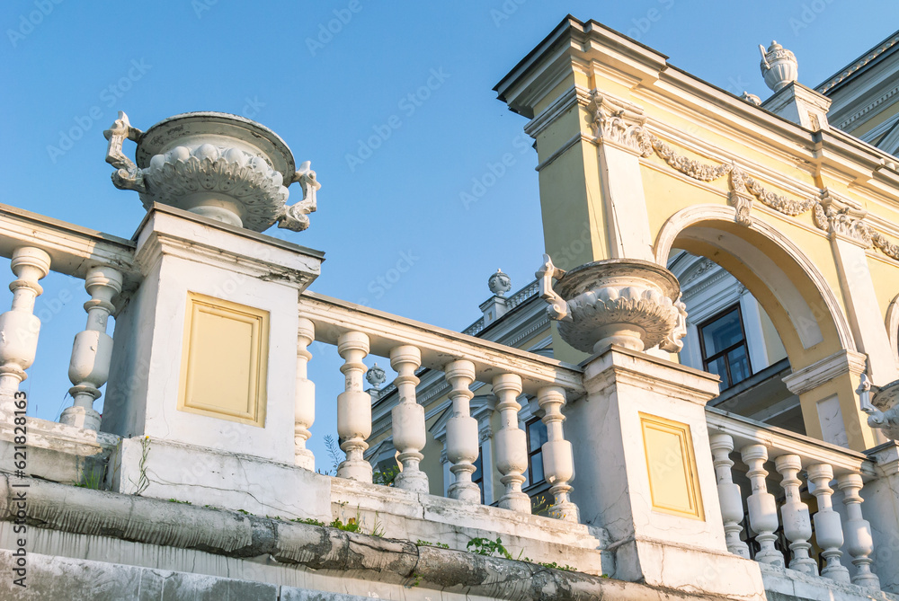 A vase made of stucco on an old building of the 19th century. A flowerpot on the facade of a mansion built in the 19th century. Ancient architecture with stucco on the facade.