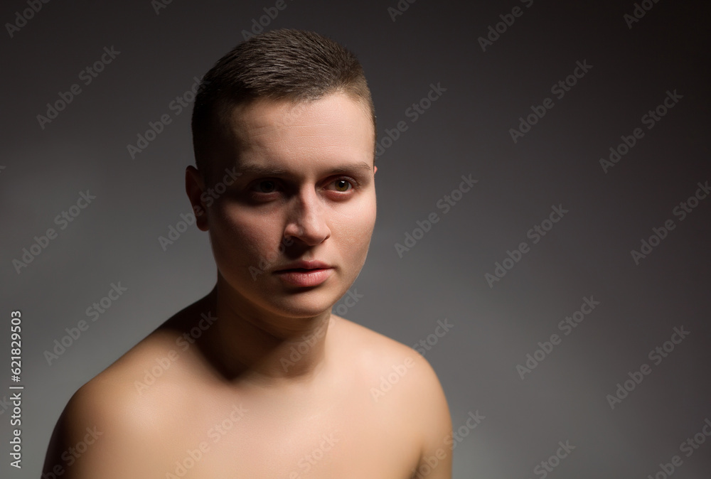 portrait of young woman with short hair and bare shoulder on grey background portrait of young woman with short hair and bare shoulder on grey background