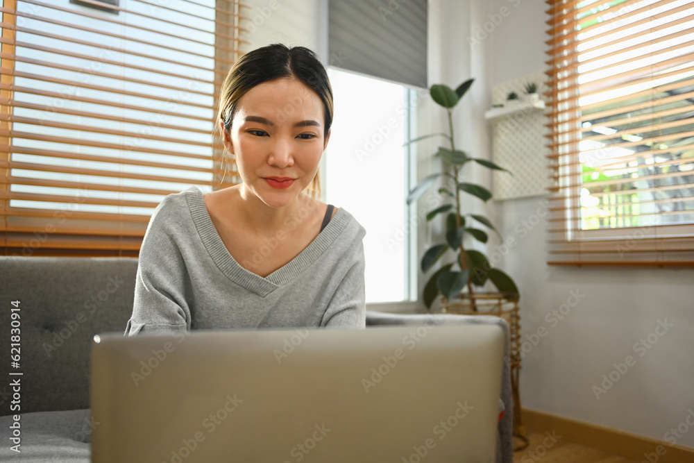 Happy young woman using laptop at home, chatting with friends in social network, watching movie and shopping online Happy young woman using laptop at home, chatting with friends in social network, watching movie and shopping online