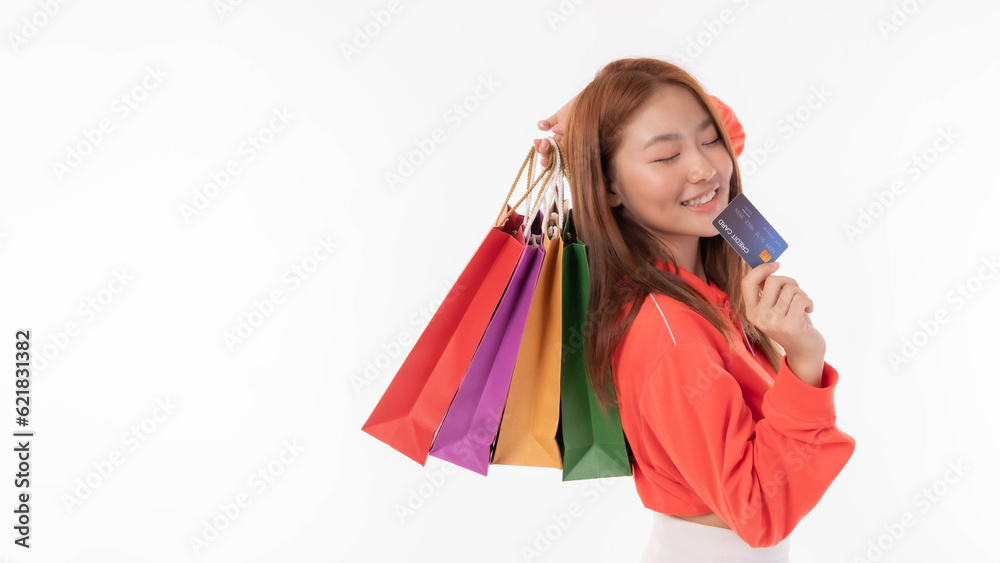 Young pretty Asian woman holding many shopping bag  and showing credit card for payment shopping isolated on white background - copy space
