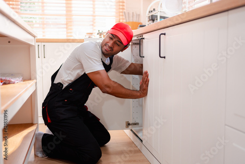 A plumber is repairing and fixing the water system in a customer's house. In-house service and troubleshooting.