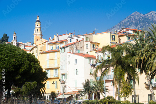 Houses and hills on the seafront, old town of Menton with blue sky.