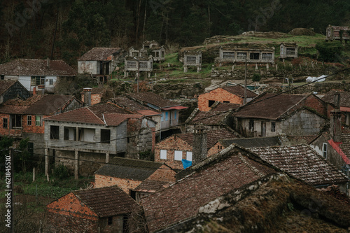 A captivating sight unfolds as we gaze upon the vast expanse of an abandoned Galician village, with its weathered granaries standing as silent witnesses to a forgotten era.