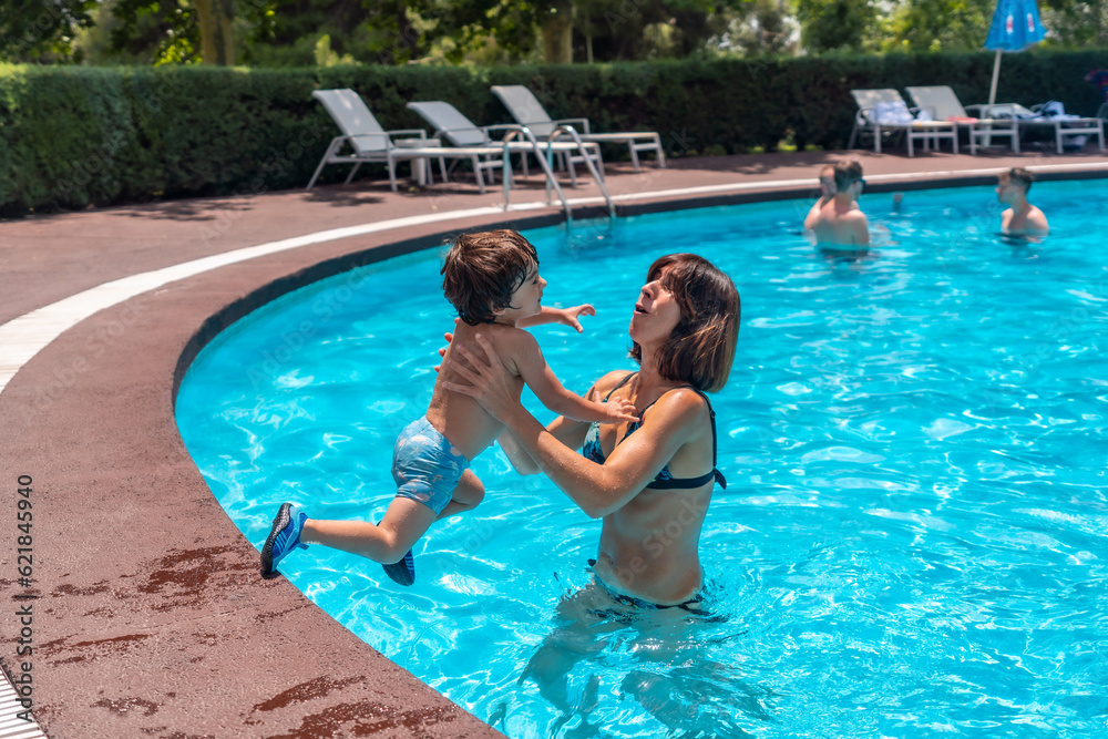 Mother and son in the pool on summer vacation, exciting vacation moment