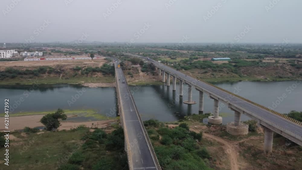 Highway bridge built over the river basin in the rural terrain, India, Aerial view, Slow motion Highway bridge built over the river basin in the rural terrain, India, Aerial view, Slow motion