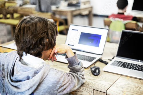 tenager boy writes codes on a computer at school in a programming lesson. Back to school. Modern IT directions in education photo