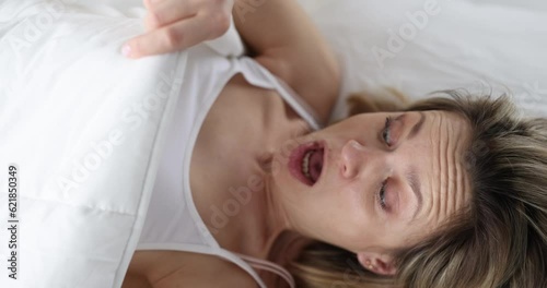 Young woman looking under covers and screaming 4k movie slow motion. Profuse uterine bleeding concept