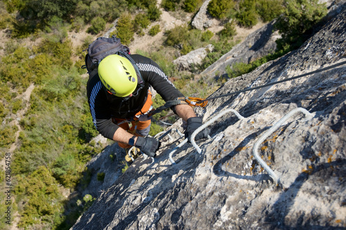 A man climbing a ferrata route in Calcena, Spanish mountains.