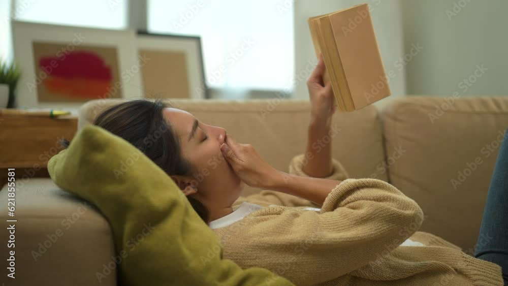 Vacation time of female reading and sleeping or nap with a book on sofa at living room. Happy woman opening, reading and relaxing a book on relax time at home. Education concept. Vacation time of female reading and sleeping or nap with a book on sofa at living room. Happy woman opening, reading and relaxing a book on relax time at home. Education concept.