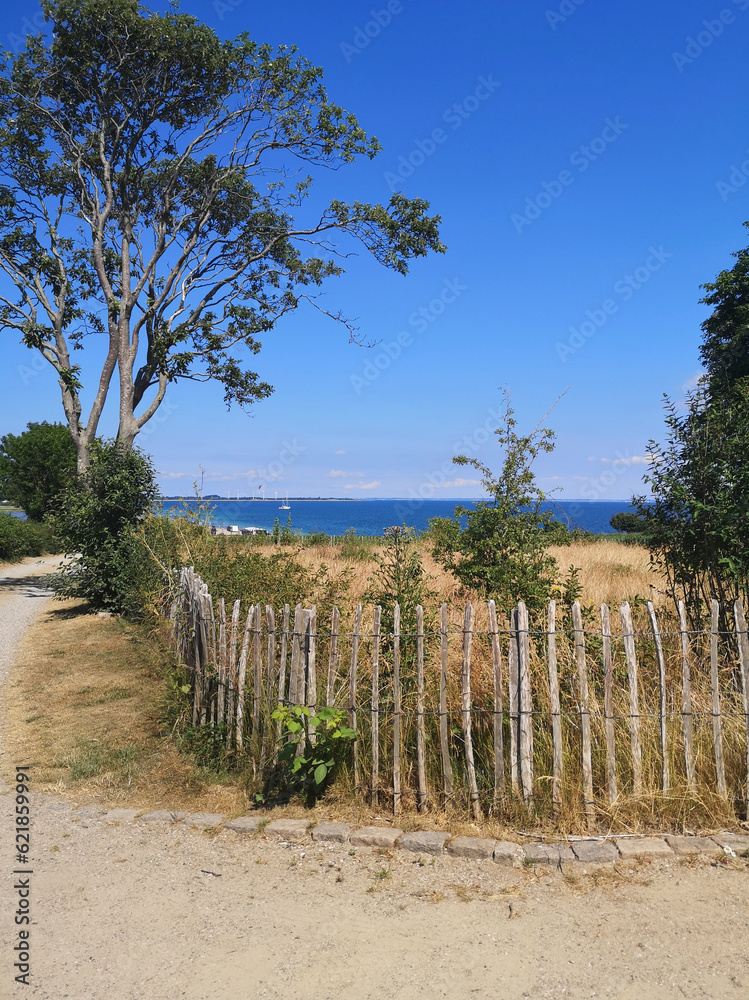 wooden fence in the foreground, blue baltic sea in the background