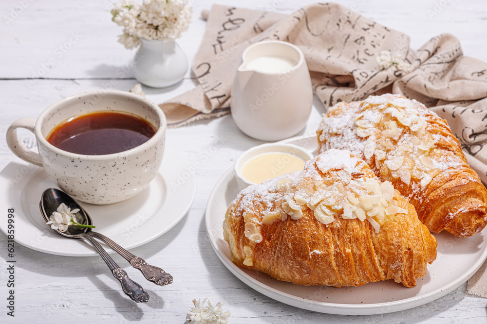Good morning concept. Breakfast with cup of coffee and fresh croissant. Sweet creamy sauce