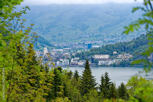 Scenic view of Lake Lucerne with Swiss Alps and mountain panorama and City of Brunnen in the background on a cloudy spring day. Photo taken May 18th, 2023, Lake Lucerne, Switzerland.