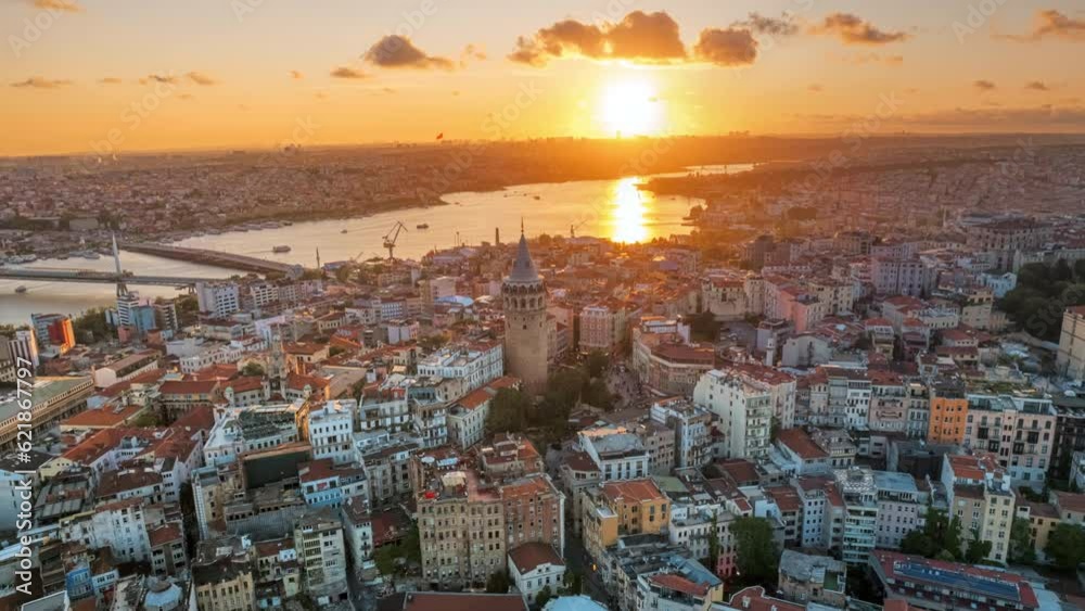 Aerial drone hyperlapse view of Istanbul at sunset, Turkey. Multiple residential buildings around the Galata tower, nightlights, Golden Horn waterway on the background