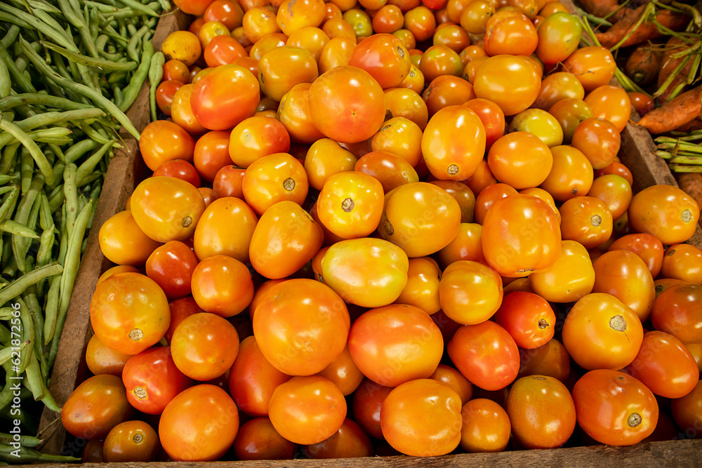 Fresh tomatoes and green beans on display at a farmers market stall. Fresh tomatoes and green beans on display at a farmers market stall.