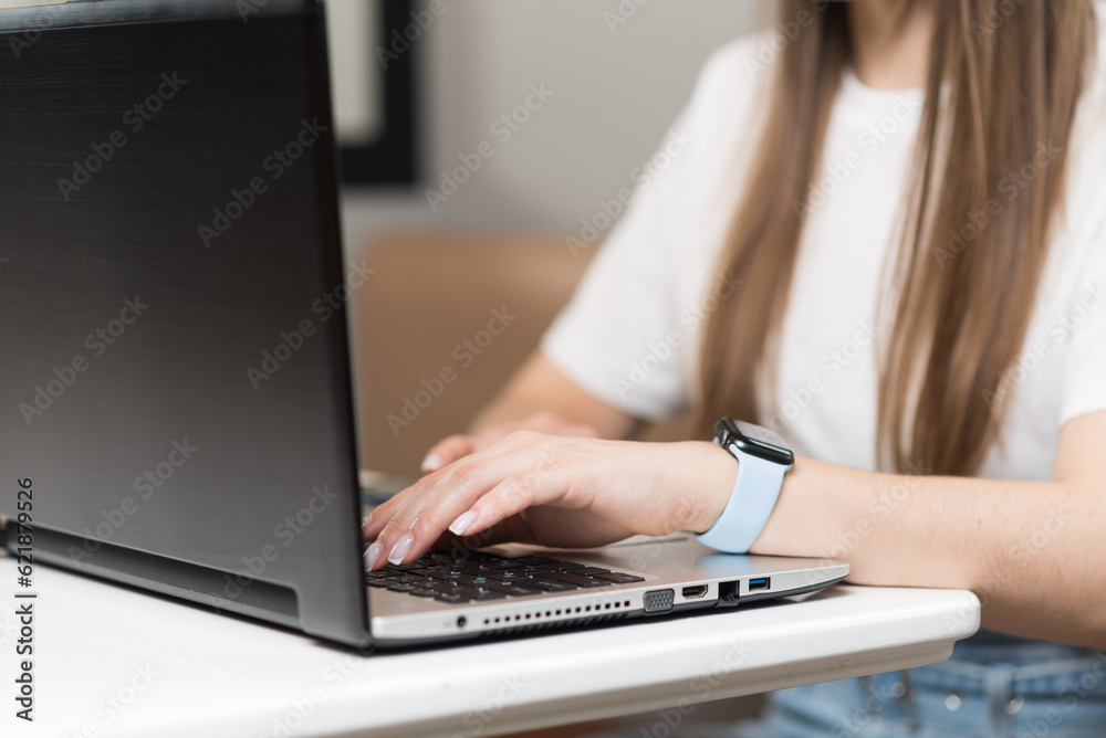 Close-up of the hands of a freelancer girl who uses a laptop in a cafe. Freelance concept.