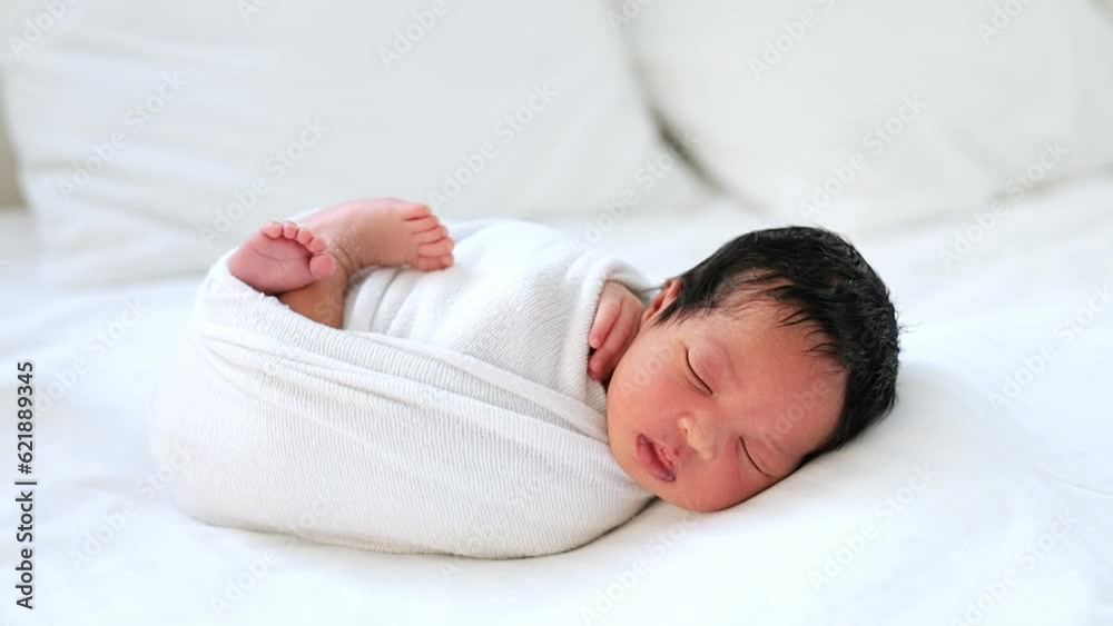 a newborn black African-American baby is sleeping wrapped in a diaper, a small dark-skinned baby is lying on the bed in the bedroom in close-up a newborn black African-American baby is sleeping wrapped in a diaper, a small dark-skinned baby is lying on the bed in the bedroom in close-up