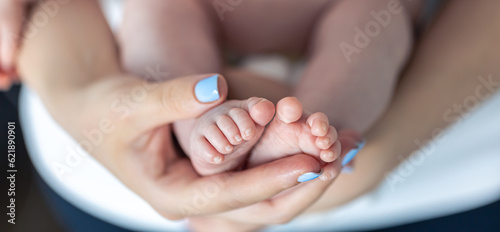 Close-up  the feet of a newborn in the hands of the mother.