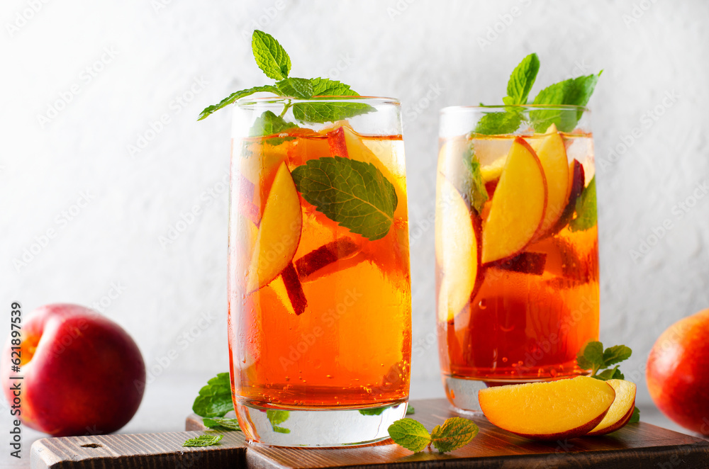 Fototapeta premium Peach Lemonade, Refreshing Drink, Cocktail, Iced Tea, Tasty Peach Cold Summer Drink on Bright Background