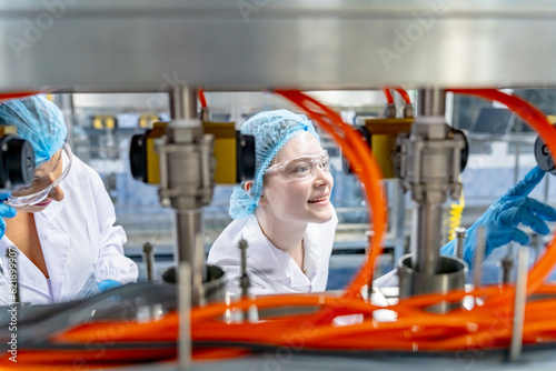 Woman working at Reverse osmosis system for power plant. RO system for industry. Young happy female worker in bottling factory checking water bottles before shipment. © FotoArtist