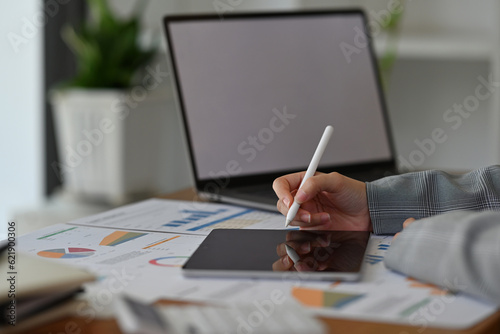 Close up image of a young businesswoman doing a financial documents on digital tablet, business data analysis concept.