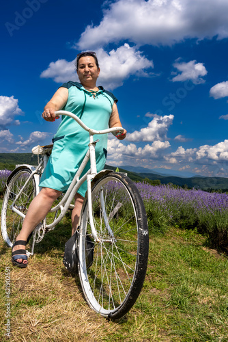 Fototapeta Naklejka Na Ścianę i Meble -  A woman on a bicycle in a lavender field. 