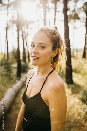 Portrait of a Young female runner stopping for a rest. Fitness woman taking a break from training outdoors in a forest.