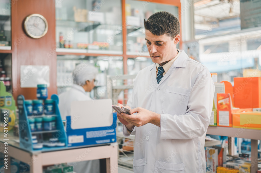 Pharmacist checking Checks Inventory of Medicine, Drugs, Vitamins and prescription medication checks in modern pharmacy.