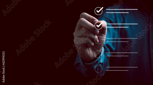 Fotografering Businessman using pen to tick correct sign mark in checkbox for quality document control checklist and business approve project concept