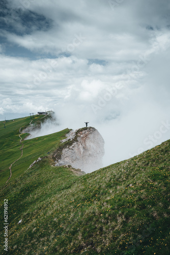 A man on top of a mountain in the clouds