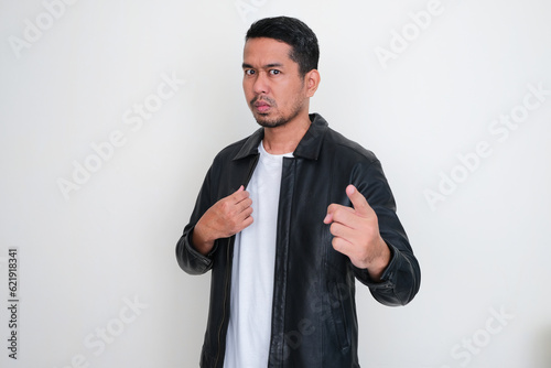 Adult Asian man pointing towards camera with threatening expression photo