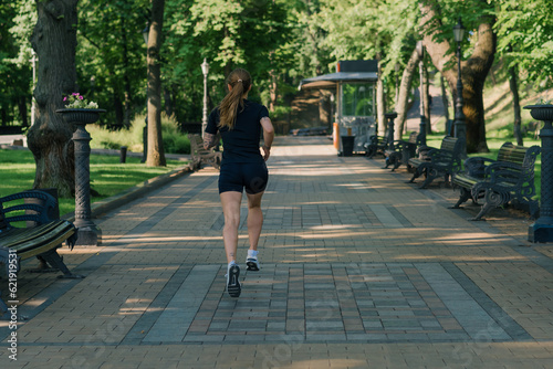 Fitness young sportswoman girl doing sports in the morning running during training outdoors in the city in the park healthy lifestyle concept